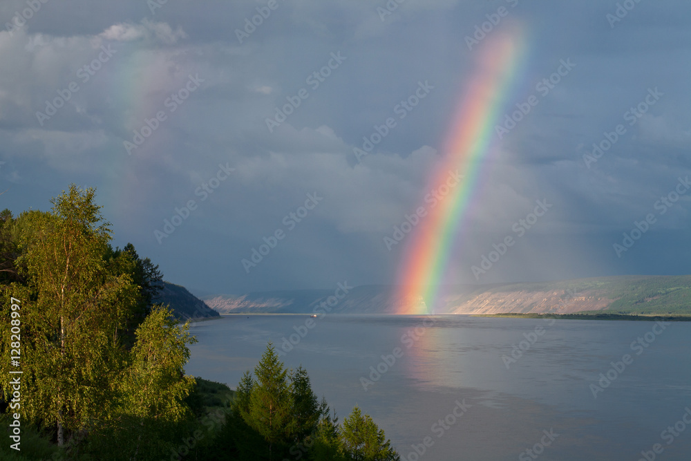 The bright rainbow over the big river. Lena river. Yakutia. Russia.