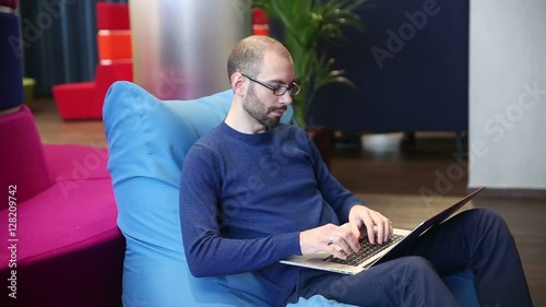 Man with glasses working on laptop