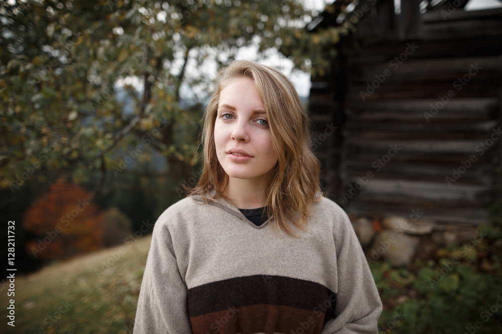 Woman in boho style. Hiker girl wrapping in warm poncho outdoor. Outdoor shot of attractive young woman Woman in boho style. Hiker girl wrapping in warm poncho outdoor. Outdoor shot of attractive young woman