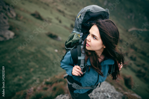 Shot of a young woman looking at the landscape while hiking in the mountains. Hair blowing in the wind