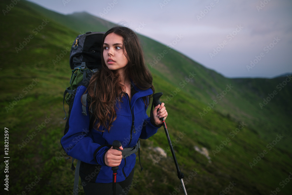 Shot of a young woman looking at the landscape while hiking in the mountains. Female hiker hiking in the mountain.