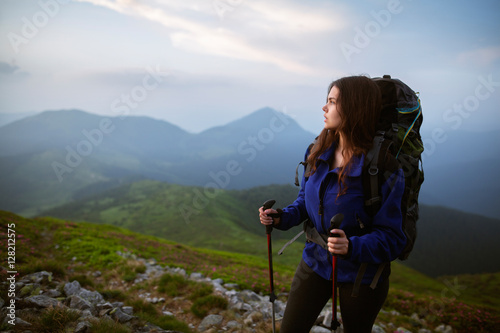 Shot of a young woman holding a map while taking in the view from the top of a mountain