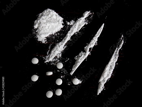 Pills and cocaine drug powder  pile and lines on black background