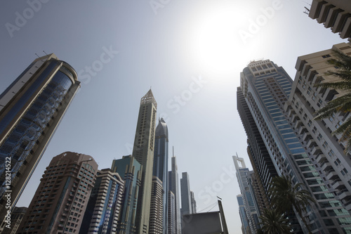 Architecture theme and concept. Panorama of tall Skyscrapers in skyline of Dubai against blue sky.