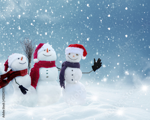 Many snowmen standing in winter Christmas landscape.