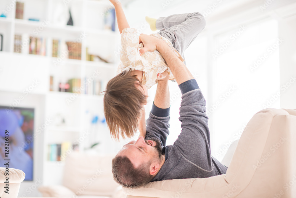 Father playing with his little son on sofa at home Father playing with his little son on sofa at home