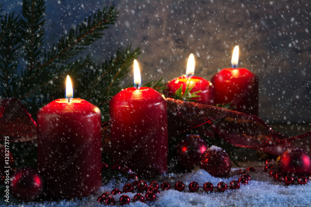 Fototapeta Four red advent candles burning on a rustic wooden board with snow