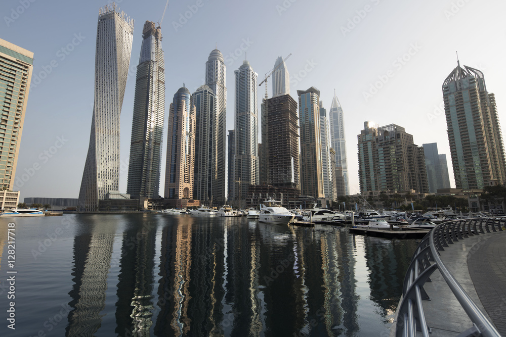 Architecture theme. Panoramic view with modern skyscrapers and water pier of Dubai Marina at sunrise,, United Arab Emirates. Luxurious property.