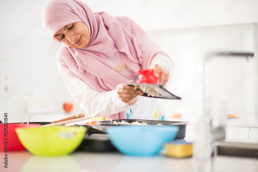 Muslim Arabic traditional woman in kitchen preparing food for lu