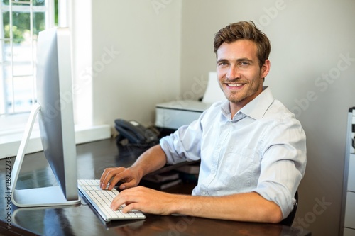 Young man working on computer at desk in office