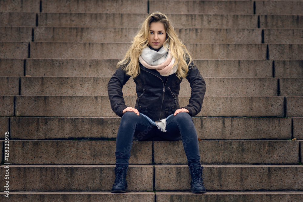 Junge blonde Frau sitzt auf einer Treppe Junge blonde Frau sitzt auf einer Treppe