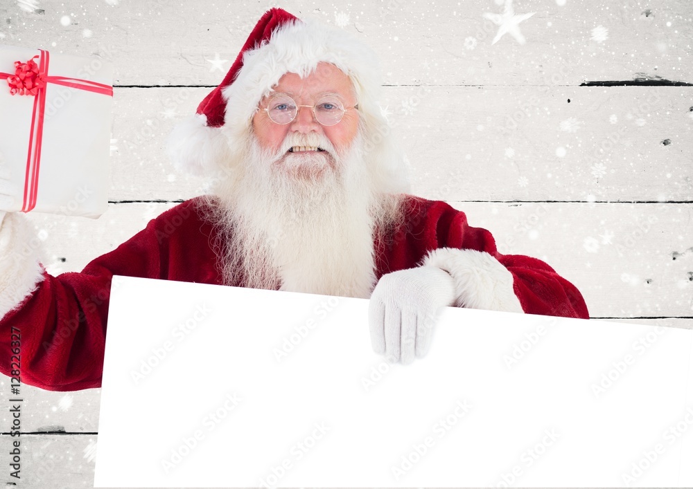 Naklejka premium Happy santa claus holding blank placard and gift box
