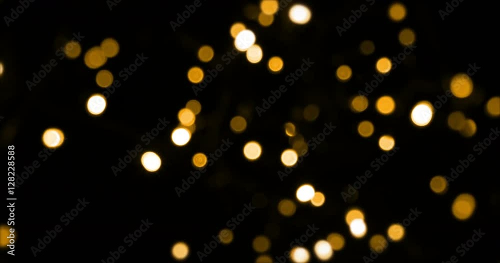 defocused bokeh gold Christmas light on dark background, zoom