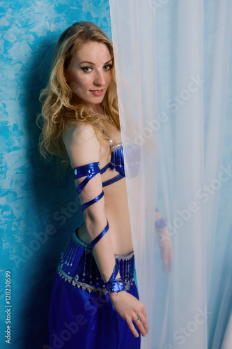 Beautiful belly dancer posing at boudoir