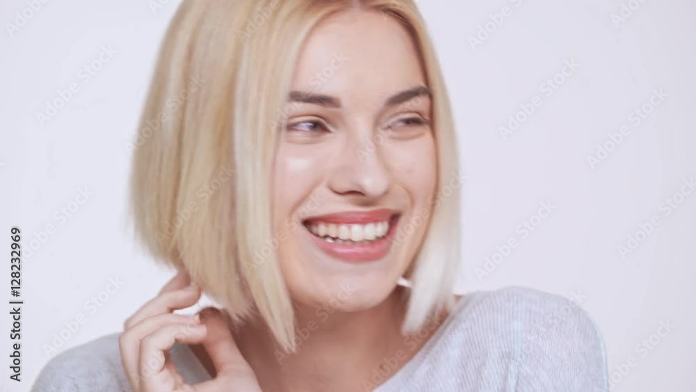 Young beautiful blond girl smiling winking flirting over white background Young beautiful blond girl smiling winking flirting over white background