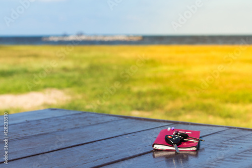 Diary,note book papers and key on wooden at beach background