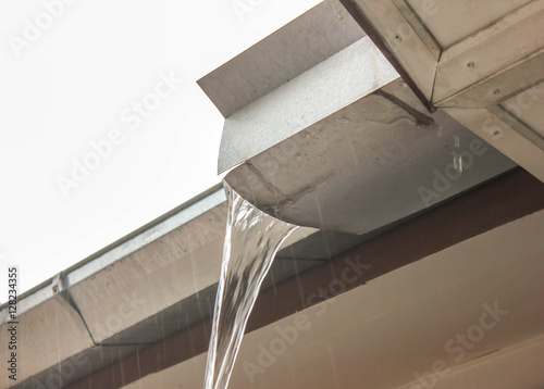 rain gutter downspout with water