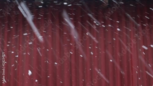 Falling snow in winter weather day over wall
