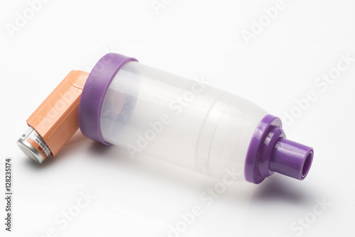 Asthma inhaler with spacer on white background