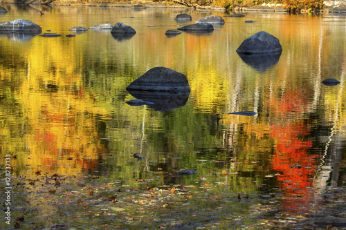 Vibrant fall colors in reflections on the Farmington River, Canton, Connecticut. photo