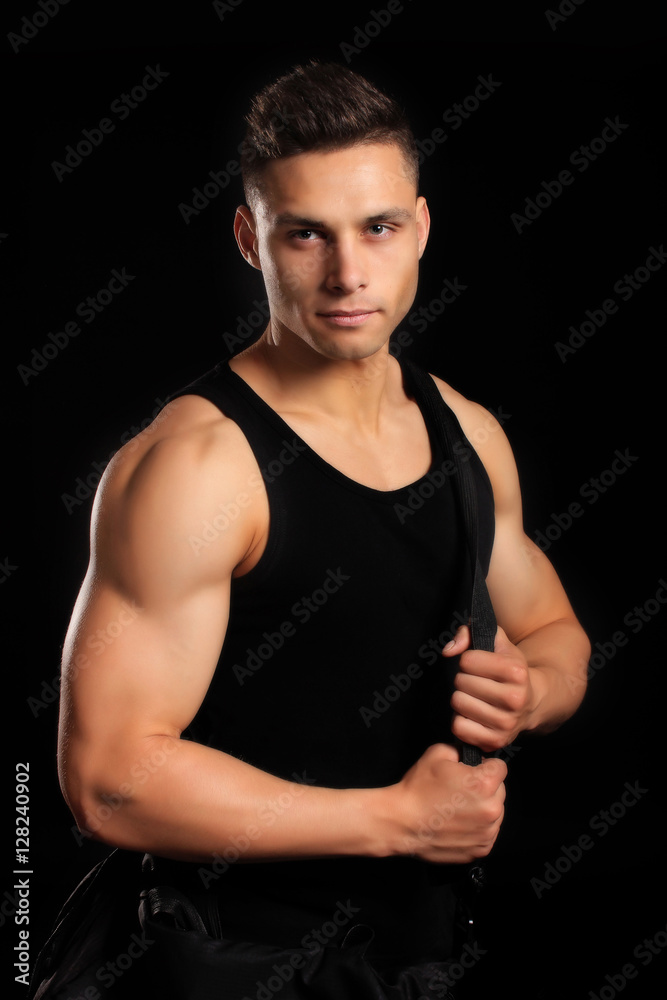 handsome bodybuilder man in a shirt with a bag showing muscles
