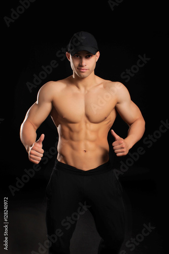 handsome bodybuilder man showing thumbs up sign with a naked torso in the cap