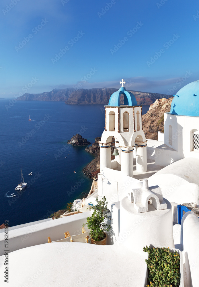 Greece. Santorini Island. Oia village. The bell tower of the Orthodox Church with the traditional blue dome against the backdrop of the Aegean Sea