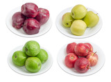 Four cultivars of apples on white dishes on light background