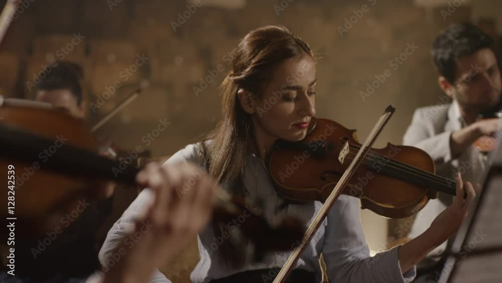 Close-up of musician playing violin on the symphony hall. Shot on RED EPIC Cinema Camera in slow motion.