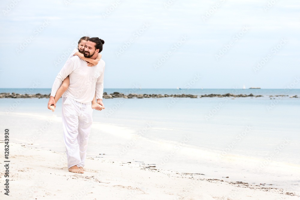 Father and daughter walking on deserted tropical beach together happy loving vacation Father and daughter walking on deserted tropical beach together happy loving vacation