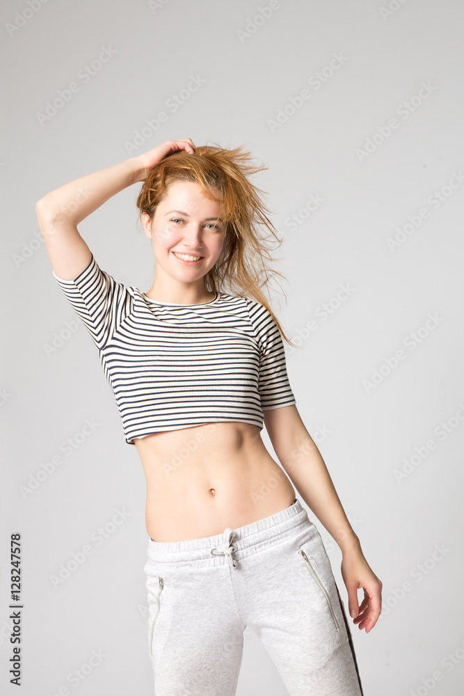 young girl in sport clothes stands and straightens her hair young girl in sport clothes stands and straightens her hair
