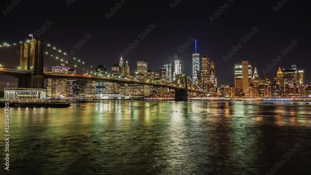 Night Manhattan and Brooklyn Bridge. The famous business district of New York. The flow of the river beautifully describes the following Night Manhattan and Brooklyn Bridge. The famous business district of New York. The flow of the river beautifully describes the following