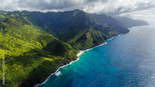 Aerial view on Na Pali Coast with Hanakapiai Falls and Hanakapiai Beach, Kauai, Hawaii. Kalalau trail is visible if zoomed in. Aerial shot from a helicopter.