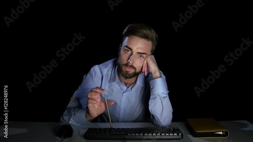 Man waiting with indifference to download the file. Dark studio photo