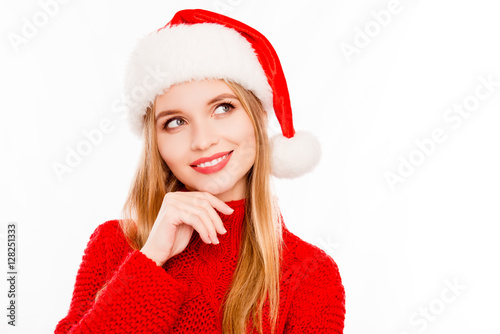 Portrait of minded woman in santa hat dreaming about gifts