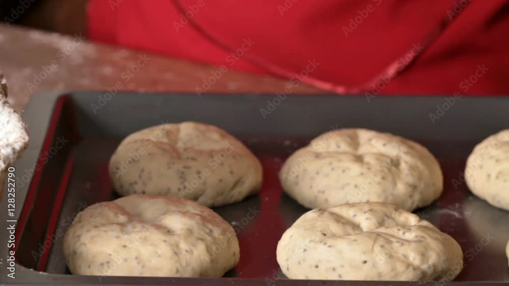 Making bakery products - glazing the buns before baking in a tray Making bakery products - glazing the buns before baking in a tray
