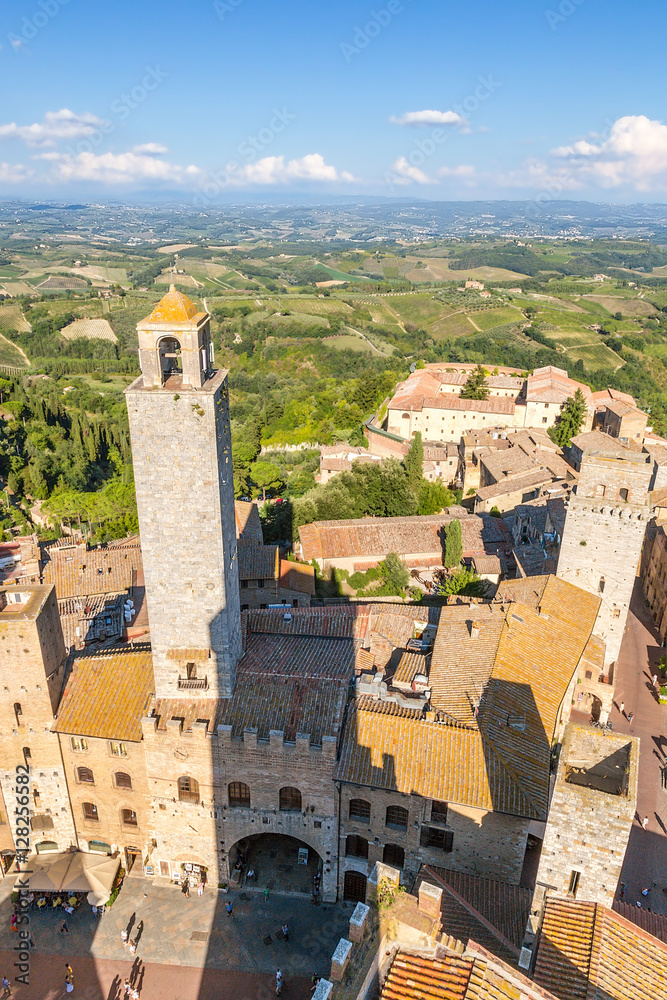 San Gimignano, Italy. View of the Cathedral Piazza del Duomo: the old palace of the Podesta (XII century) and Rognosa tower (around 1200)