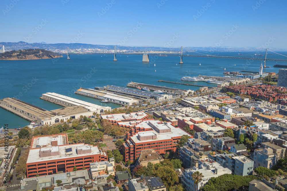 Fototapeta premium Aerial panorama of San Francisco North Beach, Embarcadero and Oakland Bridge, from top of Coit Tower on sunny day. Telegraph Hill, California, United States.