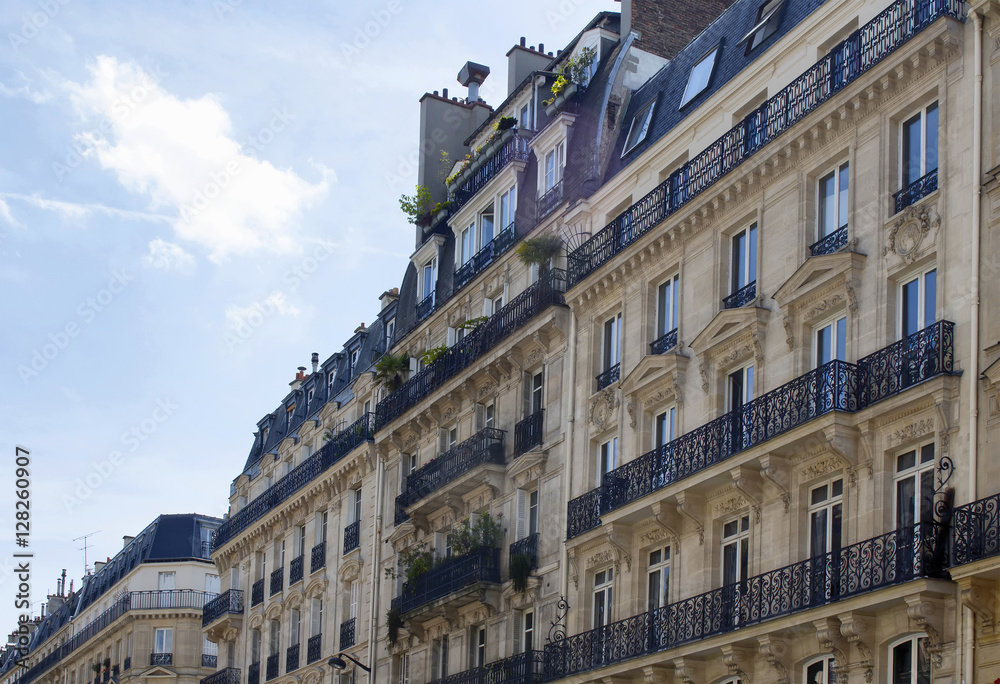 Buildings at 2nd arrondissement in Paris showing 19th century architectural style. Iron, ornamental balconies and plants are in the view.