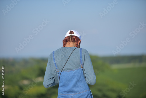 Back view of lady with white cap in jeans at garden in sunny day © mkitina4