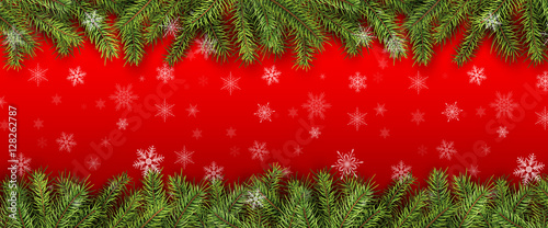 Christmas background green pine tree branches with snowflakes.