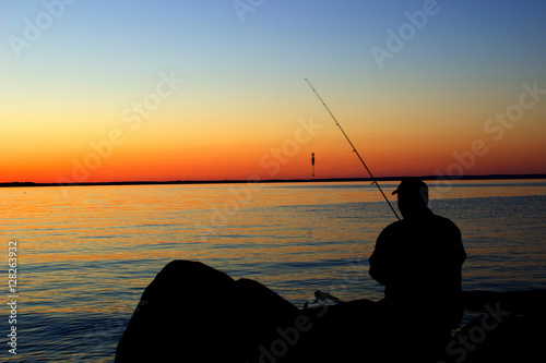 Fishing man in the lakeside sunset