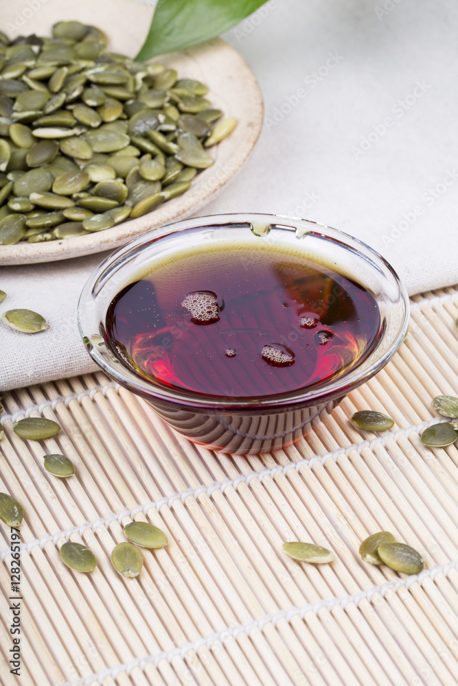 Fototapeta premium Pumpkin seed oil and seeds on the table