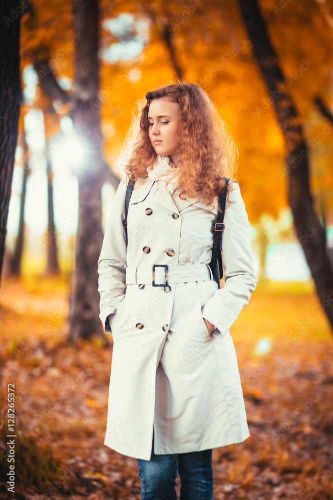 young girl in a light coat on the background of autumn park young girl in a light coat on the background of autumn park