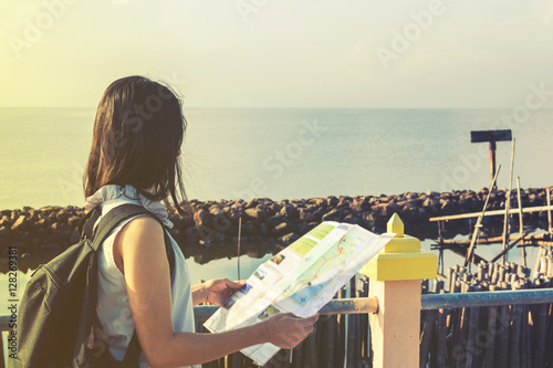 traveler girl looking at the sea with map, travel and active lif