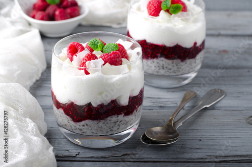 Healthy breakfast, desert, with chia seed pudding, cream, raspberry jam, coconut flakes and fresh berries