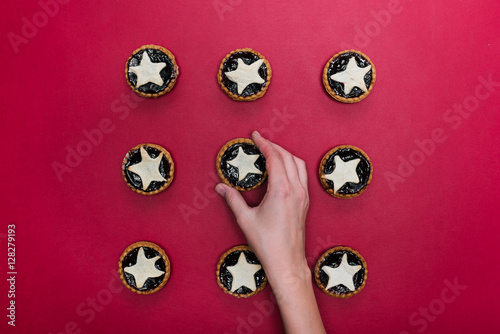 The hands put star shaped tarts on the table, top view, on red