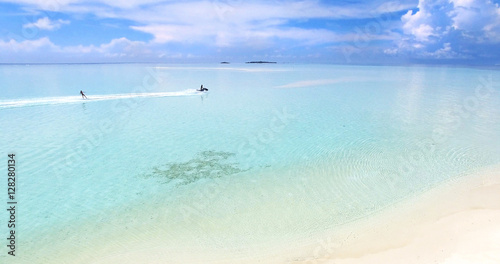 Maldives island Indian Ocean jet ski wakeboarding aerial top view. Turquoise water white sandy beach