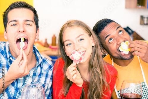 Multiracial best friends fun party eating cake with funny facial expression - Multicultural teenagers gorging on sweets with childish attitude - Concept of young people joyful momen