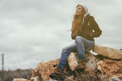 Mujer joven con ropa de urbana de otoño perdida en medio de la naturaleza 